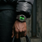 Green-dial Void watch worn on a wrist with a dark jacket