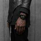 Black-dial Klaw watch worn on a wrist with a black jacket