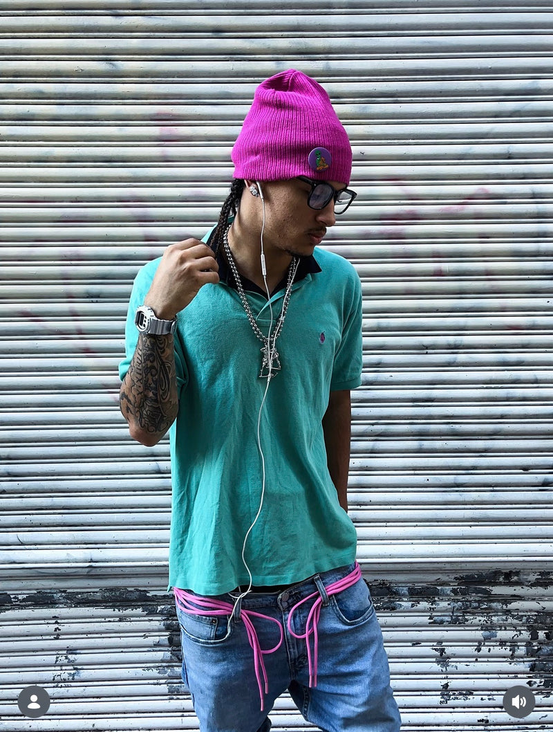 A silver digital watch styled with a turquoise polo and pink beanie