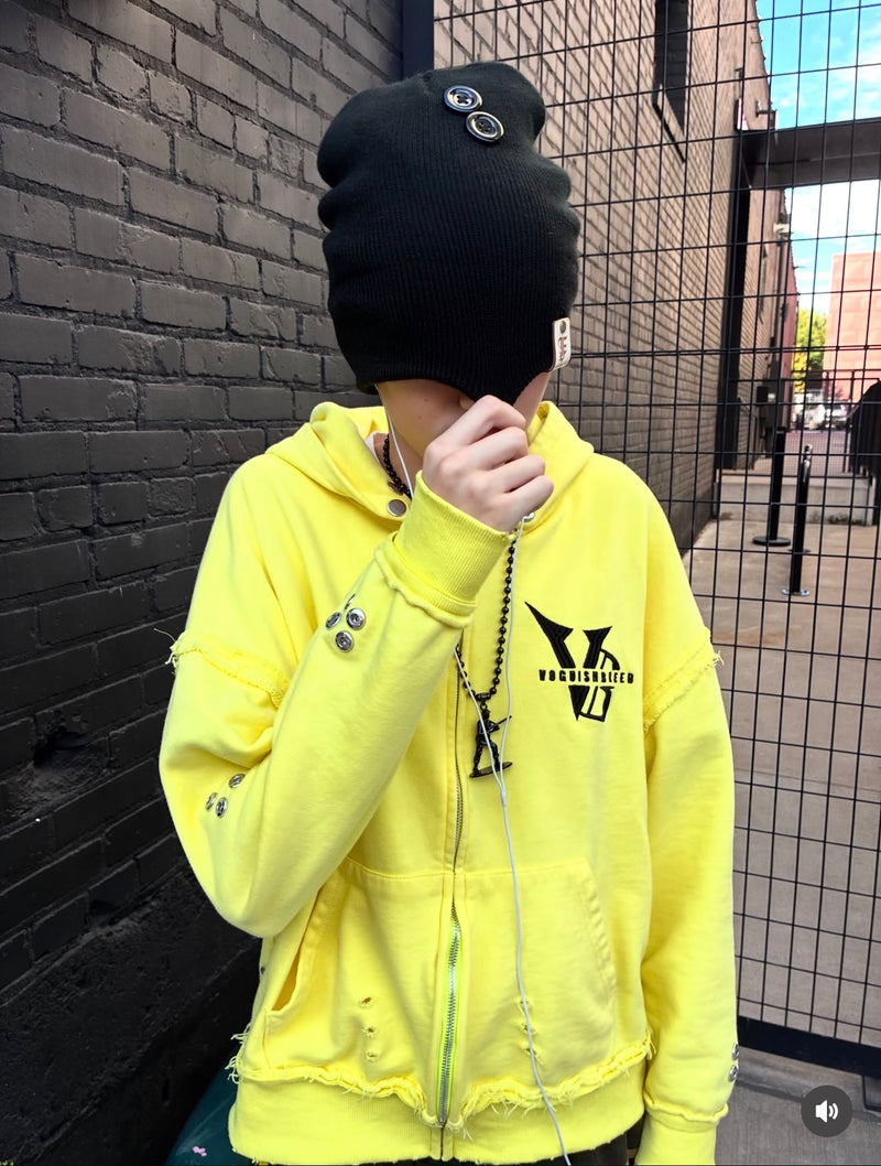 Community style with a yellow hoodie, black beanie and pendant chain